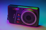 A kodak digital camera bathed in vibrant, colorful light.