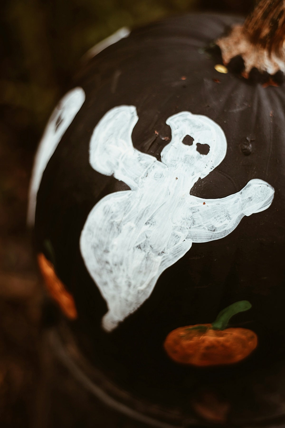 a painted pumpkin with a ghost on it