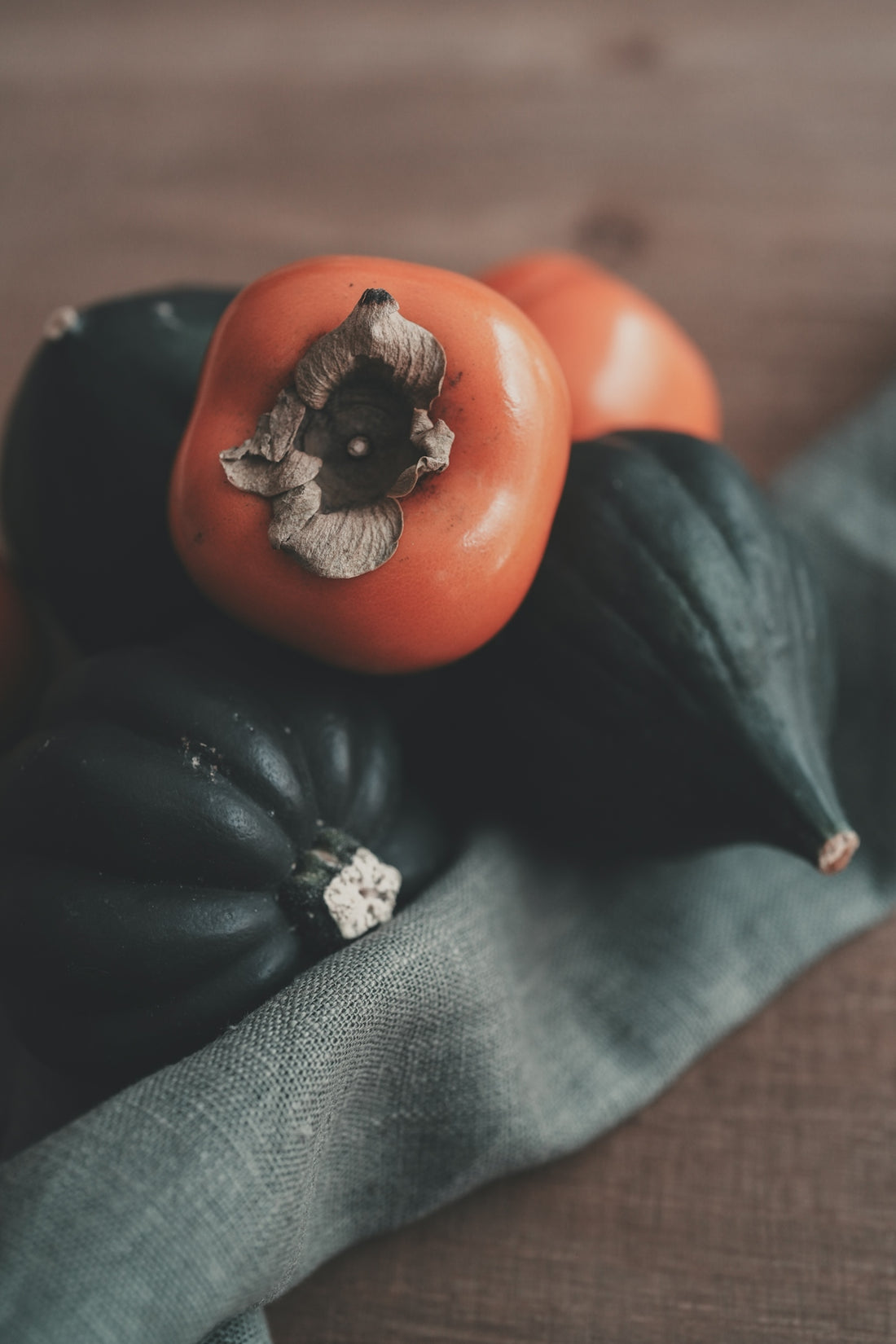 Orange persimmons and dark green acorn squash.