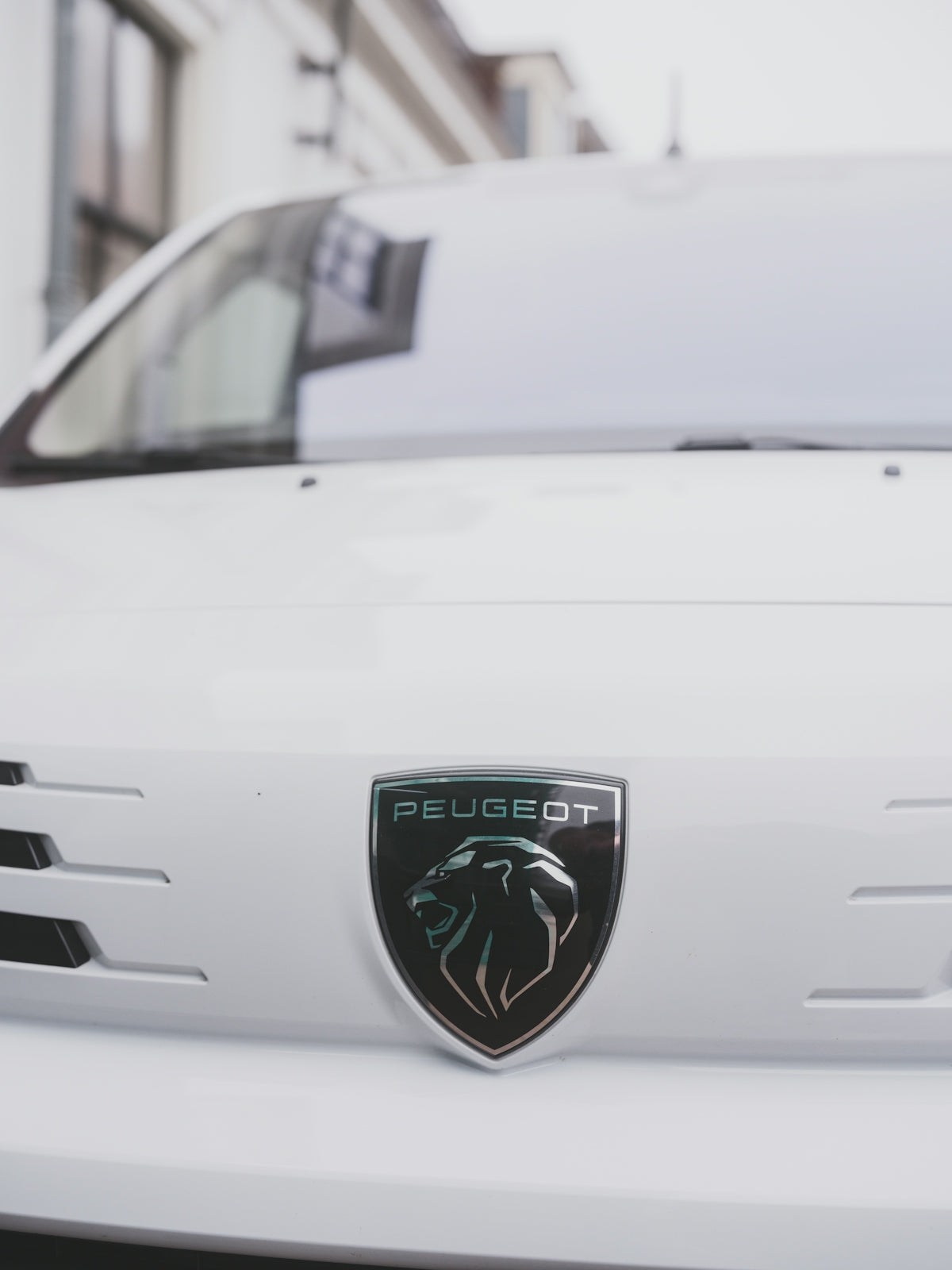 Close-up of a white peugeot car emblem